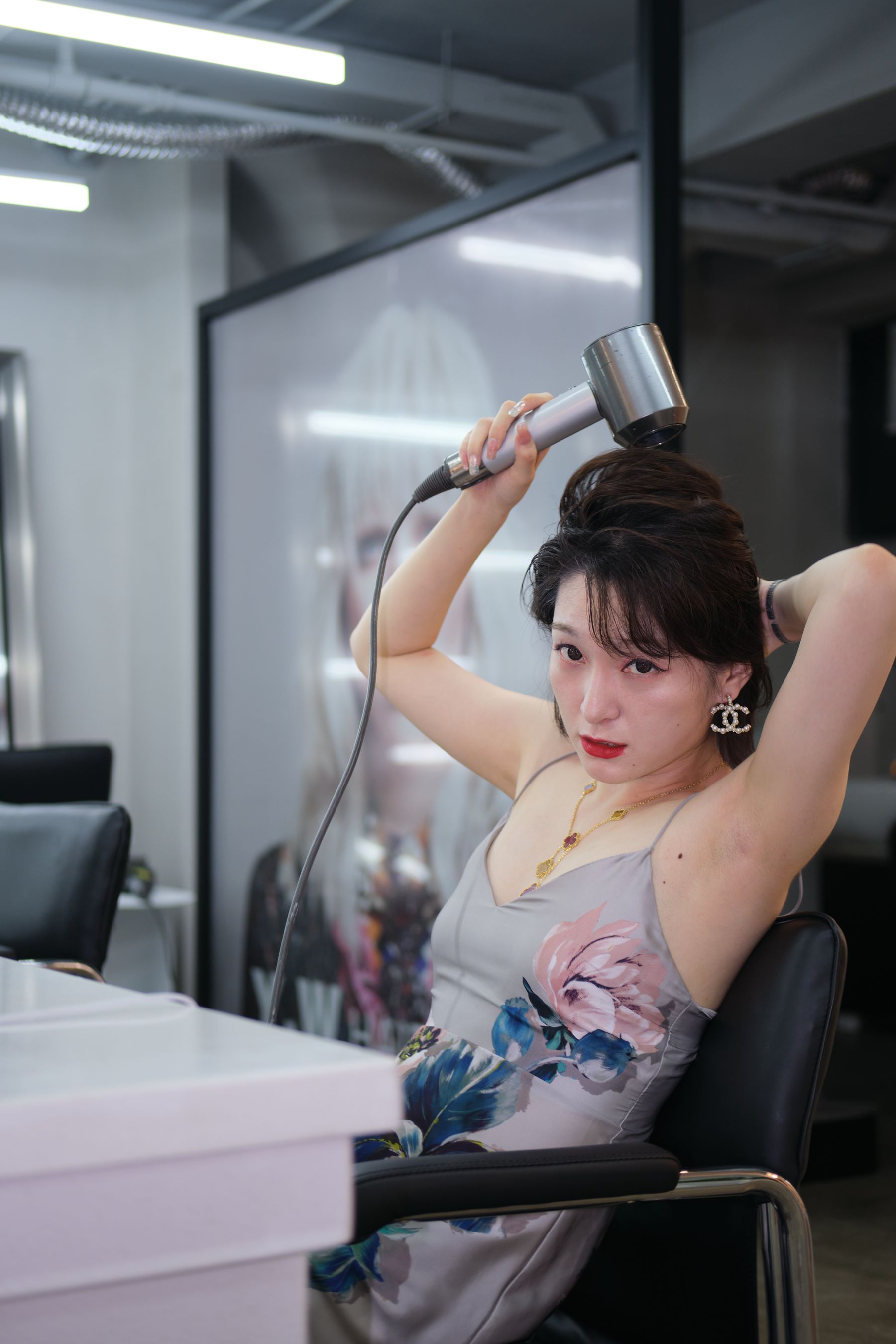 Woman blow-drying her hair in a modern salon
